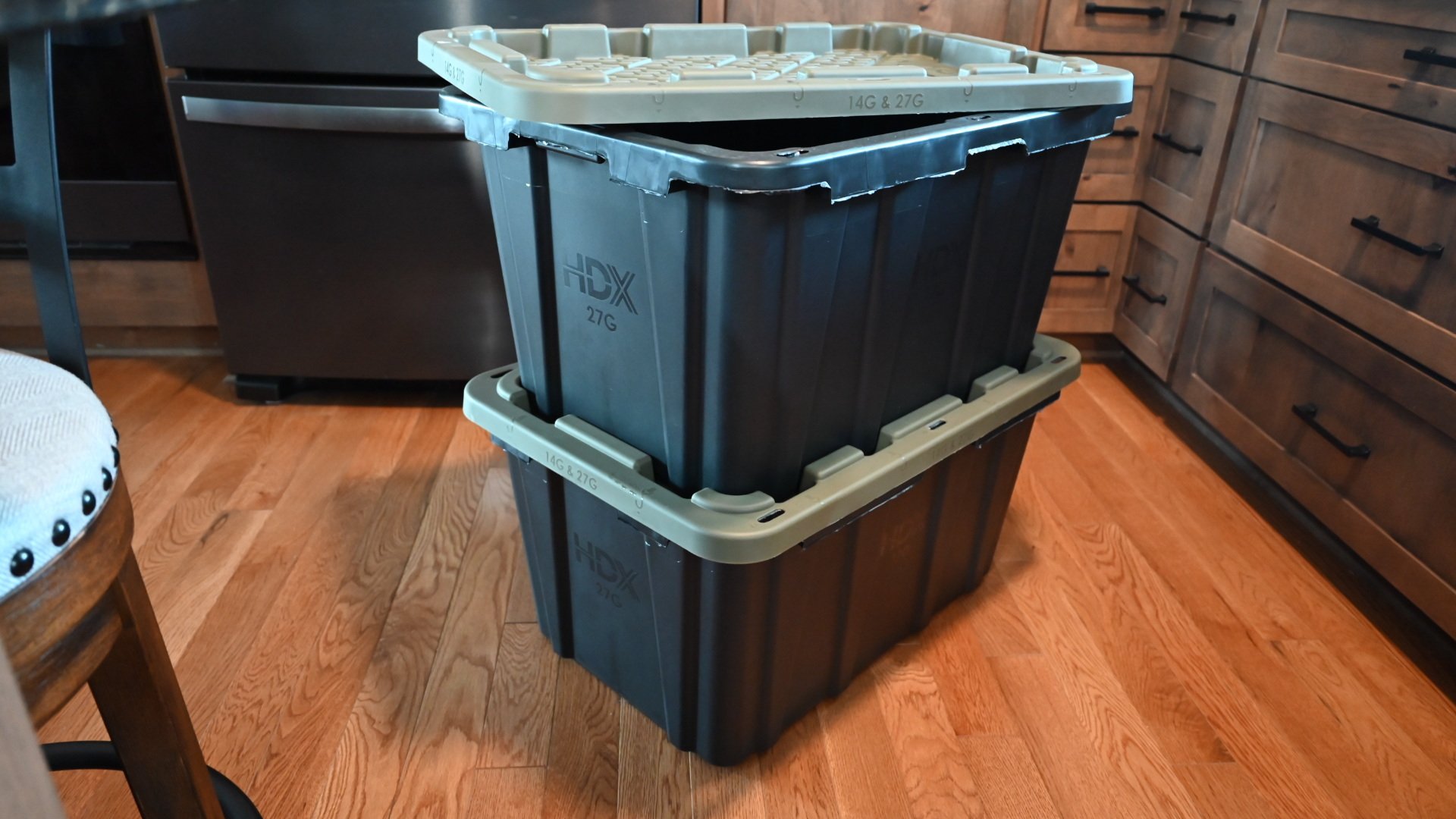 Black and green rental totes stacked in kitchen for packing 